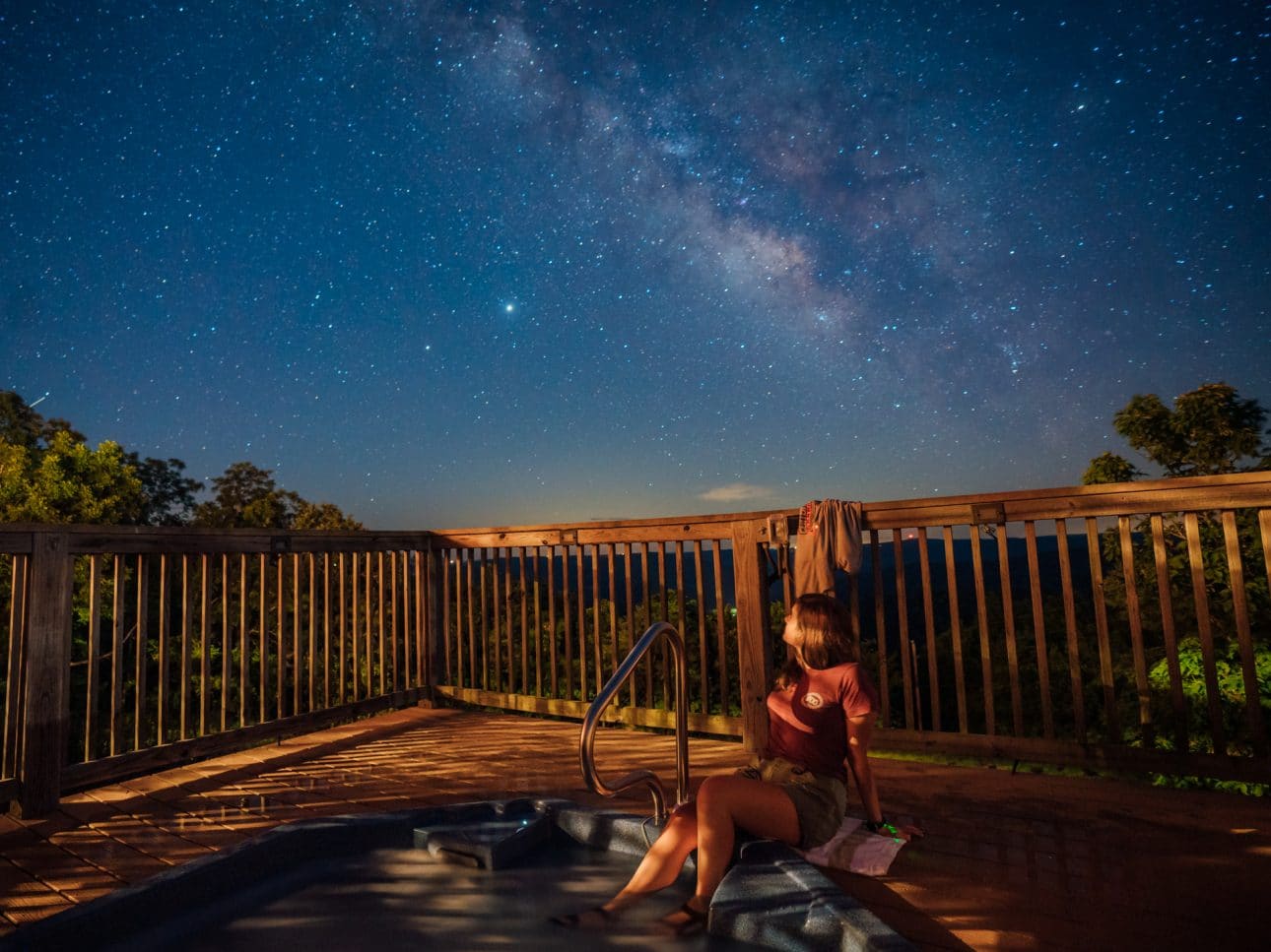 A girl views the Milky Way from the Riverwind Lodge hot-tub.