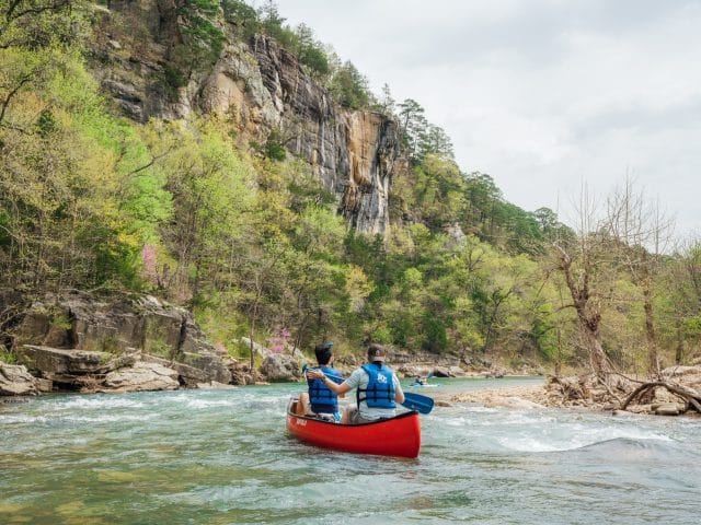 Floaters paddling below a bluff on the Buffalo National River in Arkansas..